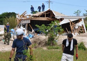 爆発事故の現場を調査する陸上自衛隊の不発弾処理隊員や警察、消防署員ら＝２６日、喜界町湾