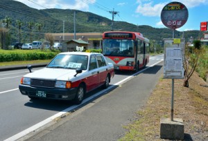 龍郷町内で運行を開始したタクシー車両＝２日、同町中勝のバス停「ビッグⅡ前」