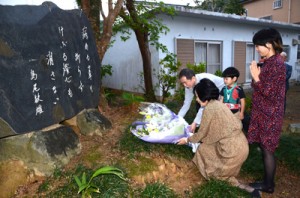 文学碑に献花する（左から）島尾伸三さんと潤井理事長ら＝１２日、奄美市名瀬