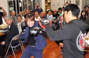 後援会主催の祝勝会でミット打ちを披露する吉田選手＝１３日、知名町