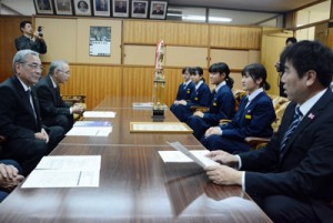 受賞を報告する朝日中吹奏楽部の（右側手前から）橋口顧問と代表生徒４人（右側）＝１２日、奄美市役所