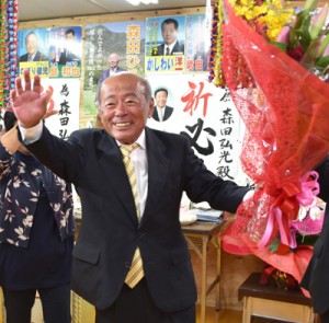 花束を手に支持者の祝福に応える森田氏＝２日午後９時２０分ごろ、天城町平土野