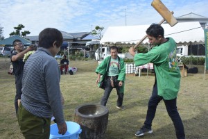 初めての餅つきを楽しむロビンさん（右）＝２３日、奄美市笠利町