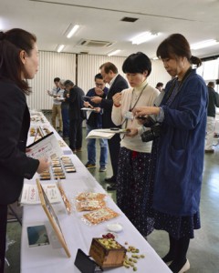 商品の特徴を審査員へアピールする出品者＝２４日、奄美市名瀬