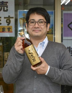 新商品「くろきび酢」をアピールする島の宝合同会社の田中さん＝１１日、奄美市名瀬の同社