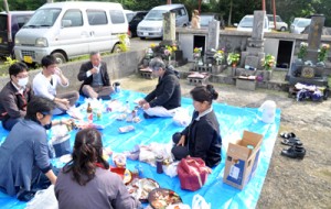 墓前で一重一瓶を囲み、先祖と共に新年を祝う人々＝１６日、知名町田皆