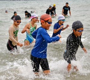 寒中水泳に挑む参加者ら＝１日、奄美市名瀬の朝仁海岸