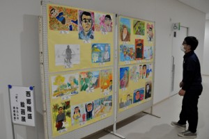 役場新庁舎１階通路に展示された児童生徒の絵画入賞作品＝１０日、和泊町