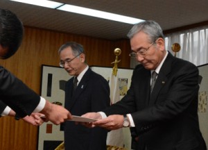 男子生徒の父親から要望書を受け取る朝山市長（右）＝１６日、奄美市名瀬