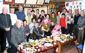 １１０歳の誕生会で花束を手にする内メギリさんを囲む親族ら＝２７日、徳之島町亀徳