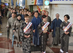  大島紬姿で商店街を練り歩き紬の魅力をＰＲする参加者＝５日、奄美市名瀬