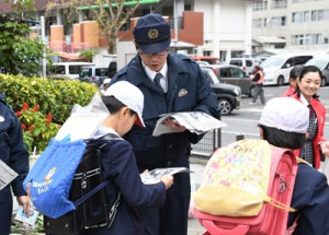 下校する児童に安全な登下校を呼び掛ける奄美署員ら＝２９日、奄美市名瀬