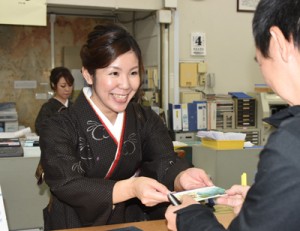 本場奄美大島紬姿で接客に当たる女性職員＝４日、奄美市名瀬