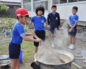 搾ったキビ汁を煮詰める児童たち＝３０日、大和村の大和小学校
