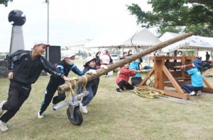 新調したサタグルマを使ったキビ搾りを体験した児童ら＝８日、伊仙町の喜念小学校