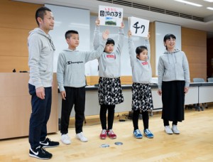 紙芝居で「方言しりとり」を披露した田代さん家族＝１０日、東京都立川市の国立国語研究所