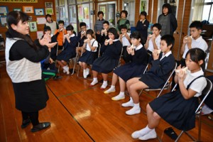 大城支部長（左）からオカリナの演奏方法を学ぶ児童生徒たち＝２６日、崎原小中学校 