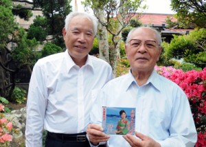 「南国エレジー」のリメイク盤ＣＤを手にする竿田富夫さん（右）と山下幸秀さん＝３０日、和泊町