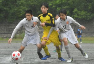 【２次予選】雨の中、ボールを競り合う小宿とＴ・Ｓ・Ｃ奄美Ｕ―１５の選手ら＝２９日、旧大島工業高校グラウンド