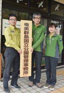 新しい看板を掲げる職員ら＝１日、大和村の奄美群島国立公園管理事務所