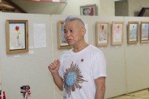 喜界島の特攻花絵画展開催の思いを語る横山さん＝２５日、町中央公民館