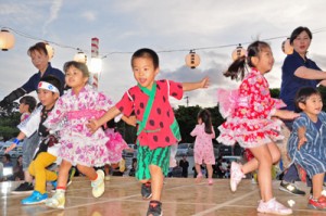 やぐらの上で楽しそうに盆踊りを踊る園児ら＝２７日、和泊町のヤーシチ公園