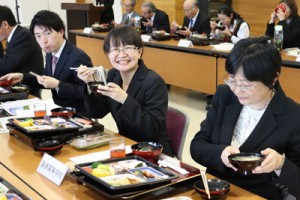 郷土料理に舌鼓を打つ転入教職員ら＝１２日、喜界町役場多目的室