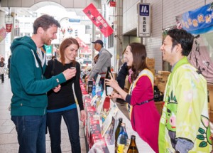 外国人観光客にも味と香りが好評だった奄美黒糖焼祭り＝９日、大阪・天神橋二丁目商店街