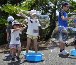 ジャンボシャボン玉に夢中の子どもたち＝５日、奄美市名瀬の県立奄美少年自然の家 