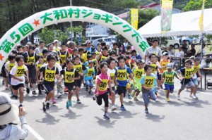 一斉にスタートを切る２㌔コースの参加者＝２６日、大和村の村体育館前