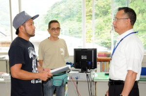 クルーズ船寄港地開発計画の白紙撤回を求める要望書を提出する加計呂麻島の住民（左）＝９日、瀬戸内町役場