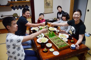 農家民宿「ほおらしゃ家」で夕飯を楽しむ熊本県の荒井弘幸さん一家＝３日、奄美市住用町