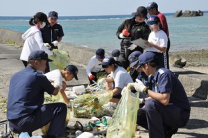 集めたごみの種類や国籍を調査する生徒ら＝２３日、龍郷町嘉渡海岸