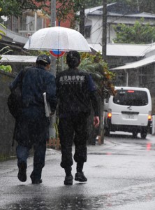事件があった現場の民家へ向かう捜査関係者＝１９日午前８時５０分ごろ、奄美市名瀬小俣町 