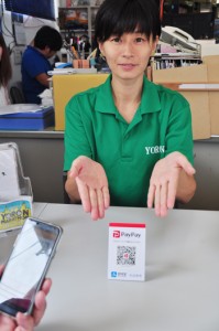 店頭にあるＱＲコードをスマホのアプリで読み取る仕組みのキャッシュレス決済＝１２日、ヨロン島観光協会事務所