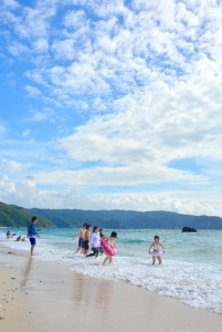 梅雨明けの青空の下、海水浴客でにぎわった浜辺＝１３日、奄美市名瀬の大浜海浜公園