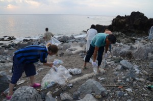 有良の海岸に漂着したペットボトルなどを拾い集める参加者＝１３日、奄美市名瀬