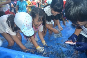 グルクンのつかみ取りなどでにぎわった与論町漁協のお魚まつり＝１５日、同町