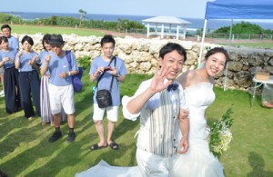 沖永良部島の海が見える場所で念願の結婚式を挙げ、笑顔を見せる大橋敏之さんと千葉里さん＝１４日、和泊町