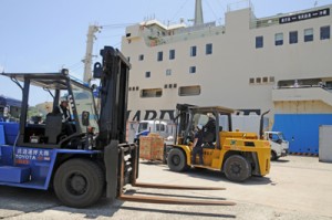 大量の生活物資が届き、荷役に追われる作業員＝１２日、沖永良部島の伊延港