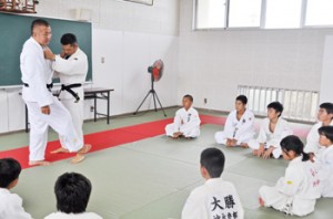 子どもたちに柔道を教える鈴木さん(左)＝１９日、和泊町