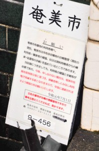 永田墓地の利用者の登録申請を呼び掛ける立て札＝１１日、奄美市名瀬