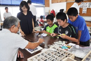 講師と一緒に貝の名前を確認する児童生徒＝２２日、奄美市笠利町