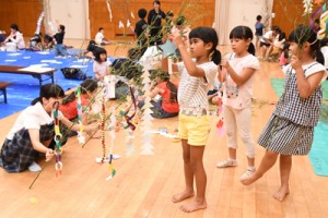 七夕の飾り付けを楽しむ子どもたち＝６日、徳之島町亀津