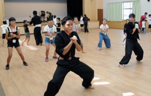 地域の高校生から応援団の演舞を学ぶ小学生＝２６日、瀬戸内町きゅら島交流館