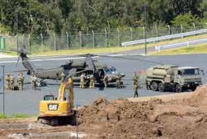 日米合同訓練で、陸自奄美駐屯地に着陸した米陸軍のブラックホークと米兵たち＝１６日、奄美市