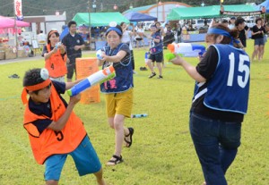 チーム対抗で必死に水を掛け合う水てっぽう合戦参加者＝１日、奄美市住用町