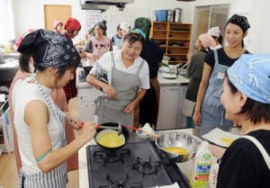 福田さん（中央）の指導で料理に取り組む参加者＝２３日、瀬戸内町