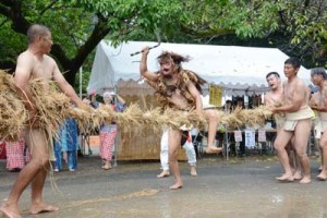 異形の者が鎌で綱を３回切る「綱切り」で幕を明けた油井の豊年踊り＝１３日、瀬戸内町油井