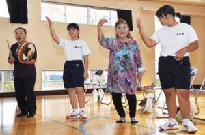 地域住民を講師に八月踊りを練習する生徒＝１７日、龍郷町